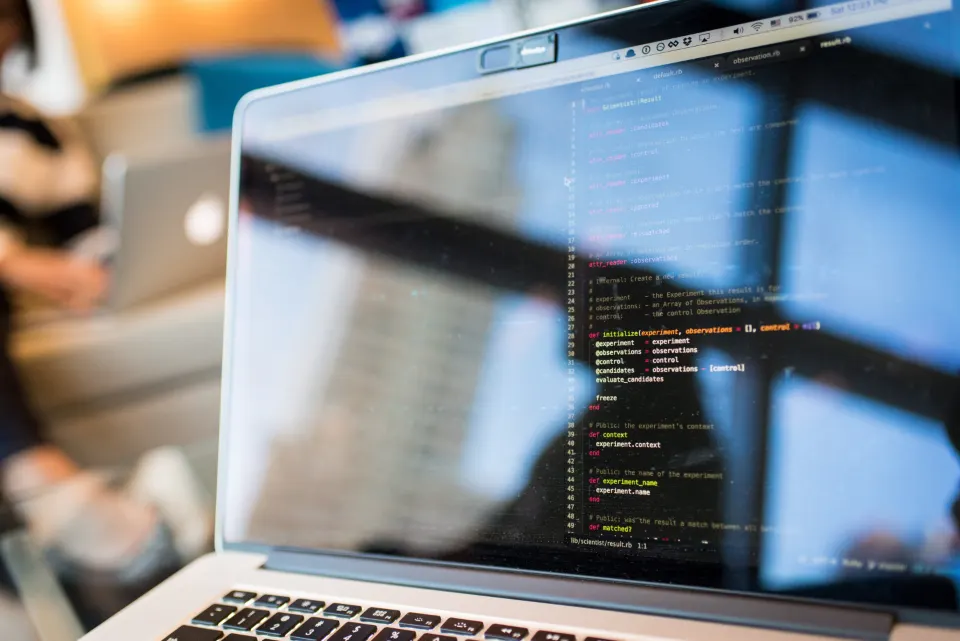 Code on a laptop screen in a bright office